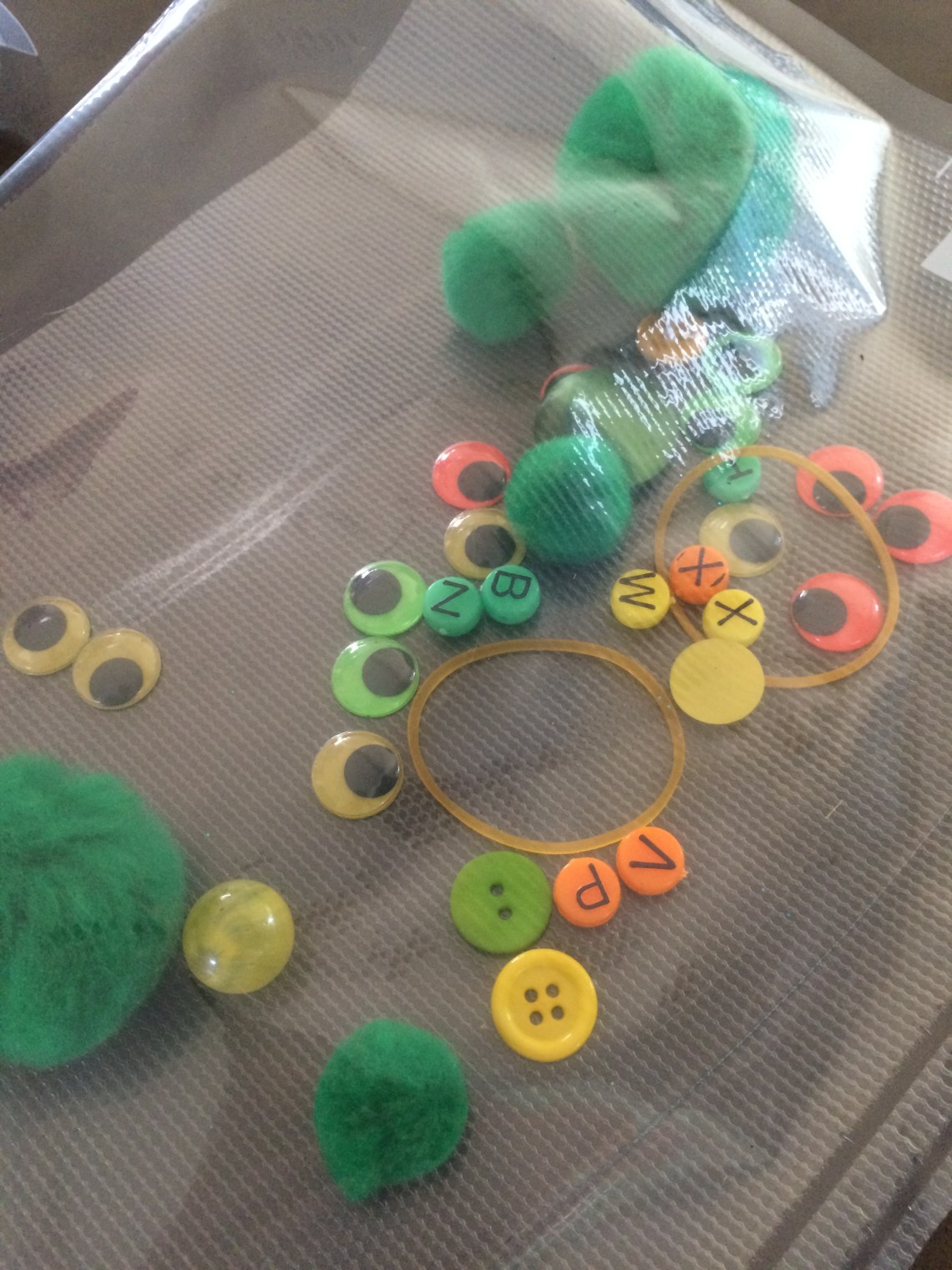 contents green glitter sensory mat pompoms rubber bands beads foodsaver sealer